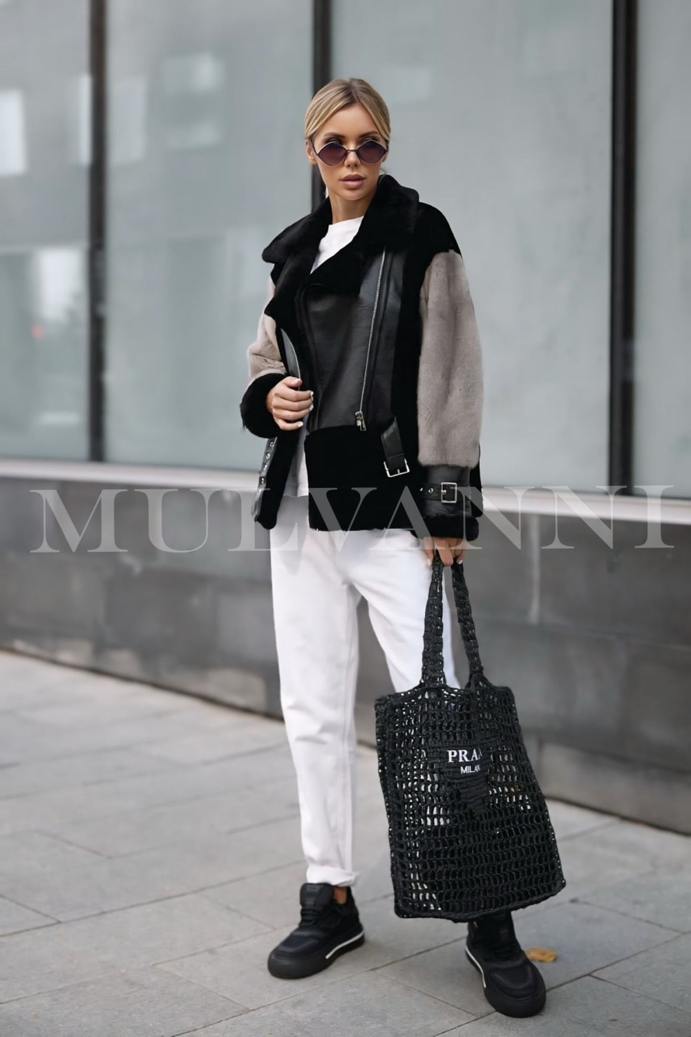 A woman dressed in a chic leather jacket featuring elegant grey mink fur details. The combination of leather and fur adds a touch of luxury, making it a fashionable choice for cold weather.