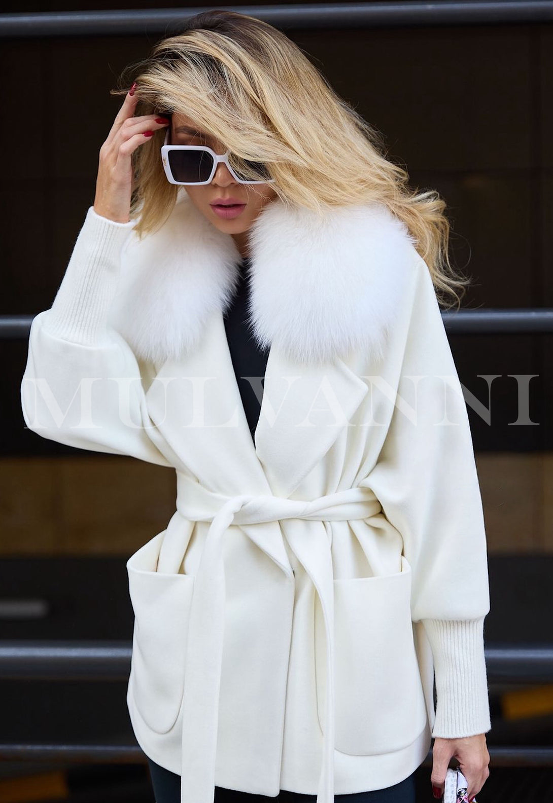 Loose-fitting white cashmere coat for women, accented with luxurious fox fur detailing. The coat has a soft, warm texture and a minimalist design, perfect for adding a touch of sophistication to any outfit.