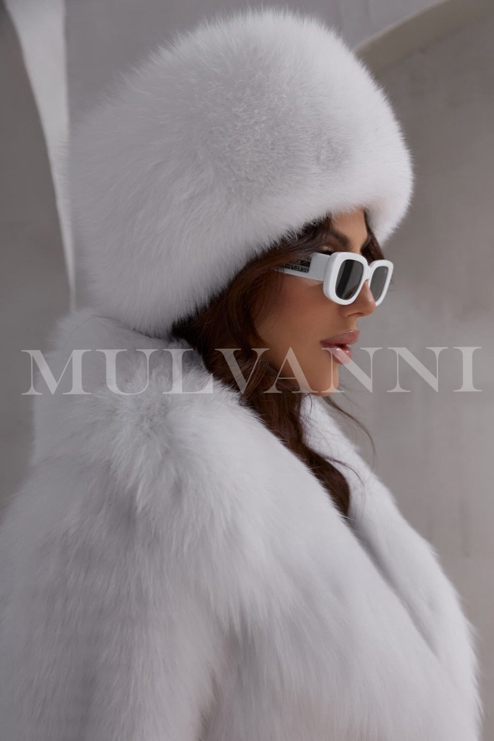 Woman wearing sunglasses and a white fox fur hat for woman showcasing high quality. 