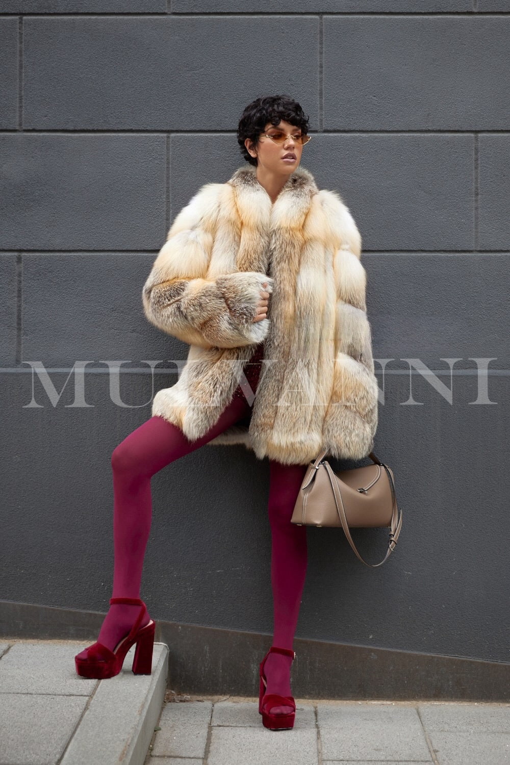 Woman wearing a gold fox fur coat showcasing very high quality fur, warm and chic for winter weather.