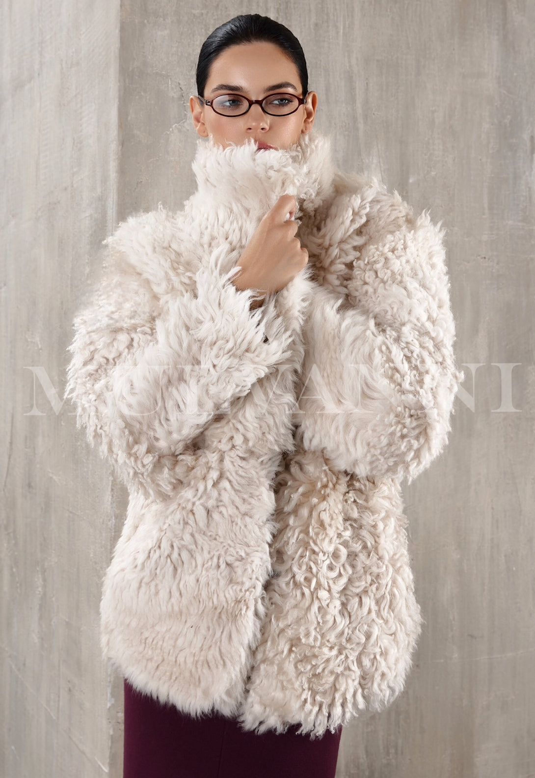 Short beige shearling coat for women, with a soft, fluffy interior and a tailored fit. The coat has large buttons, a wide collar, and hits just above the hips, creating a warm yet fashionable look.