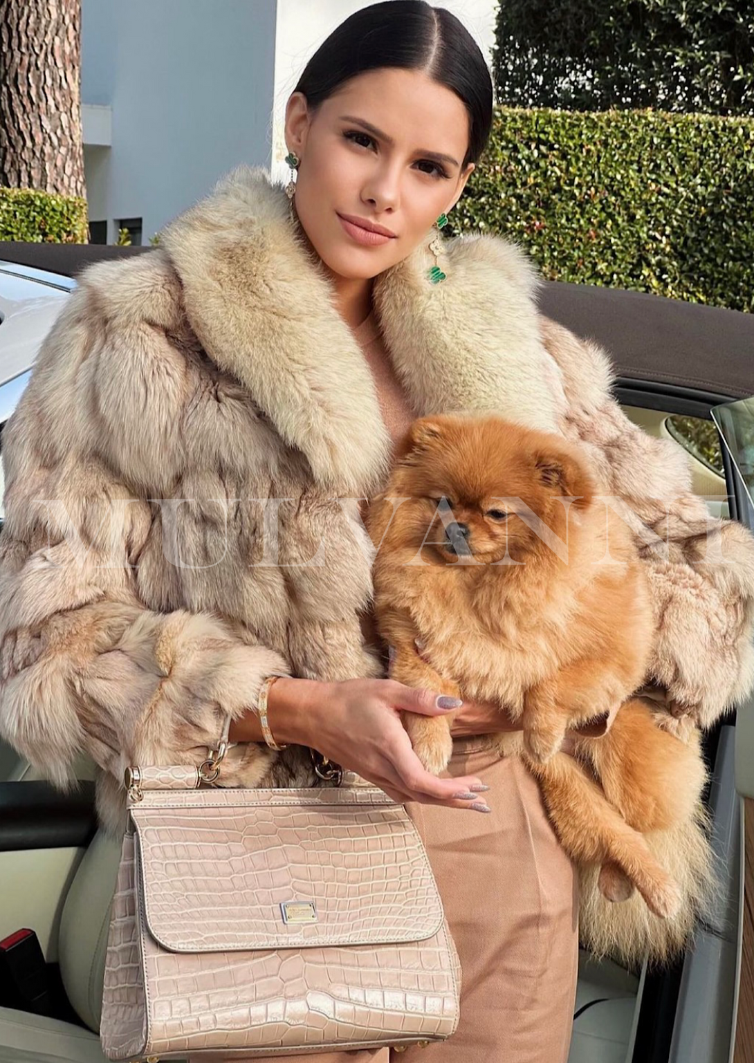 A stylish woman in a beige textured fox fur coat with a dramatic oversized collar. The rich fur and sophisticated silhouette create a chic and cozy look for cold weather.