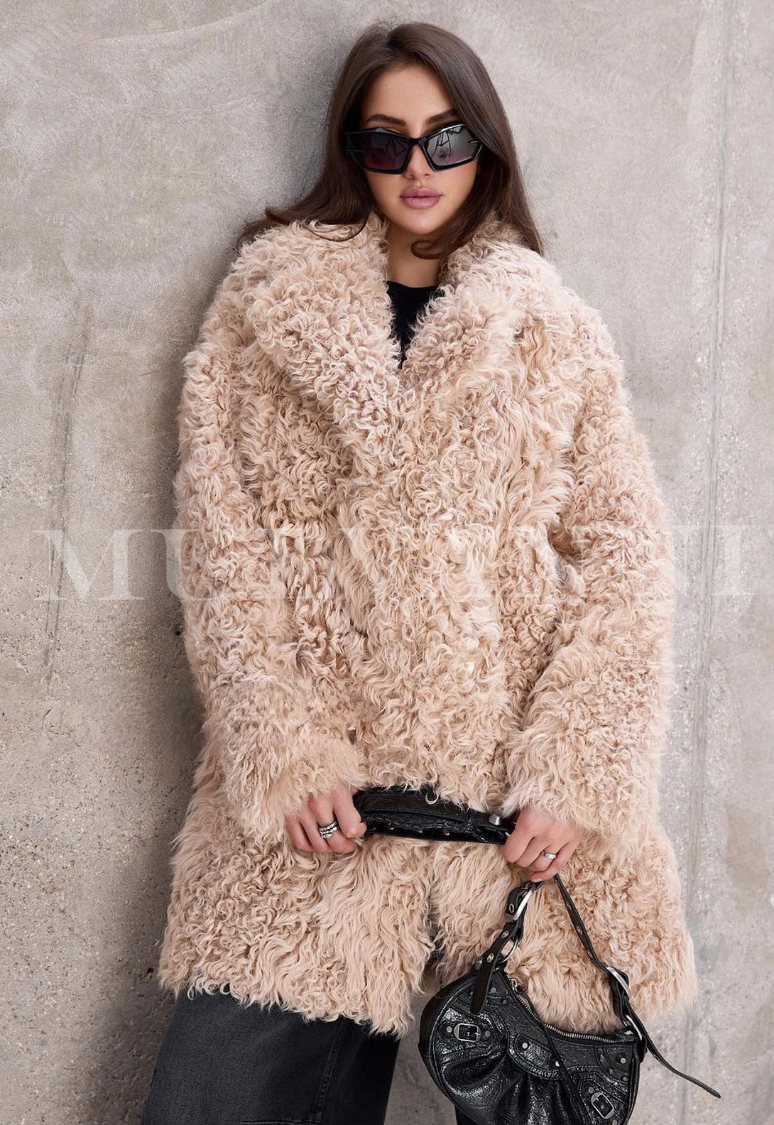 Fashion-forward woman in sunglasses, rocking a beige shearling midi coat ideal for winter style.