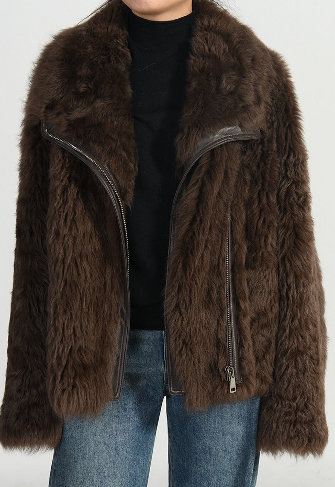 A woman wearing a a short brown shearling jacket for women with a warm, fluffy lining and a sleek, fitted design.