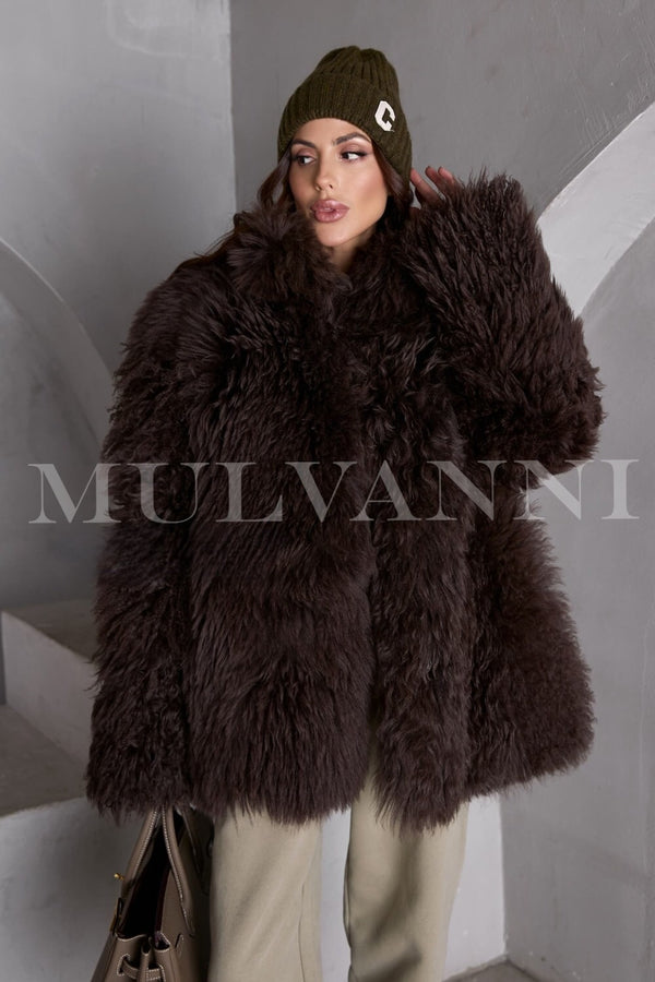 A women's brown shearling coat featuring a soft, fluffy interior and a warm, textured exterior. The coat has a classic silhouette, wide lapels, and button closures, offering a stylish and cozy option for winter wear.