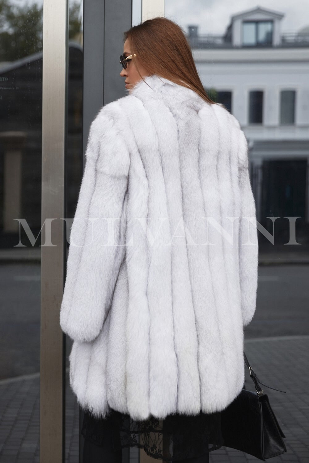 A woman in a luxurious midi white fox fur coat sourced from SAFA FURS, showcasing superior craftsmanship 