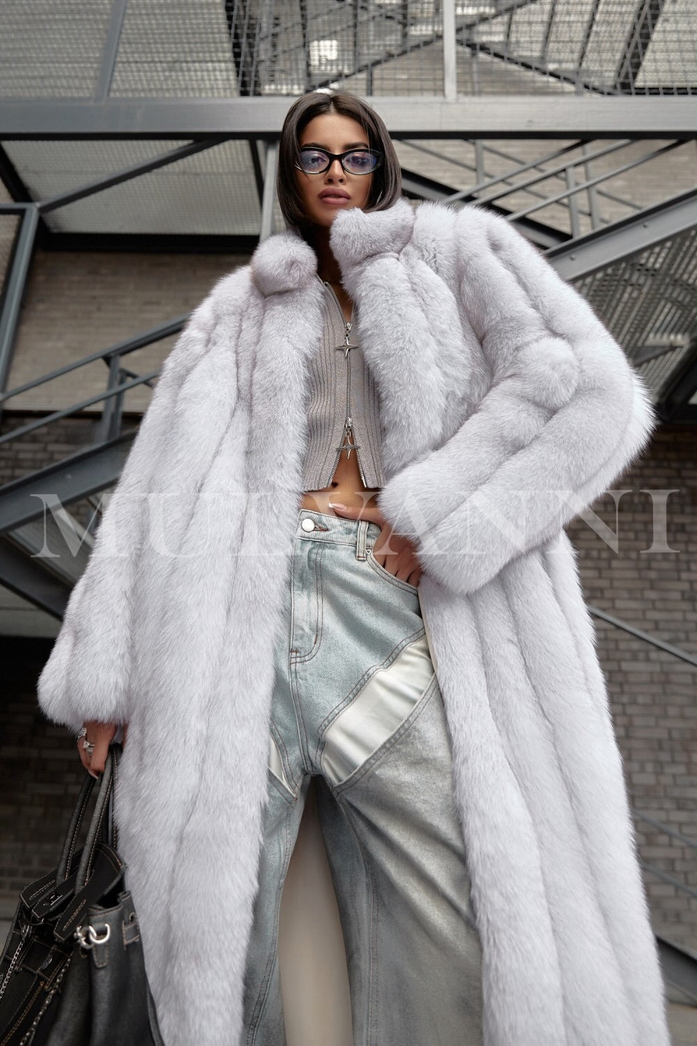 A woman in a fashionable long white fox fur coat that combines opulence and warmth. The coat's plush texture and tailored silhouette create a glamorous look, perfect for winter outings.