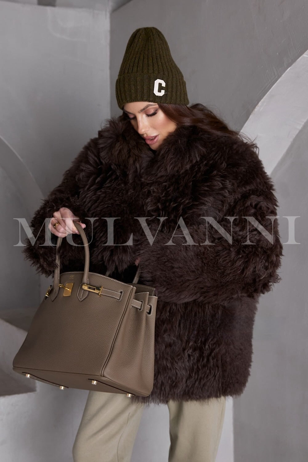 A cozy brown shearling coat for women, showcasing a plush, insulating interior and a sleek, fitted design. The coat features a double-breasted front, oversized lapels, and side pockets, blending warmth with elegance.