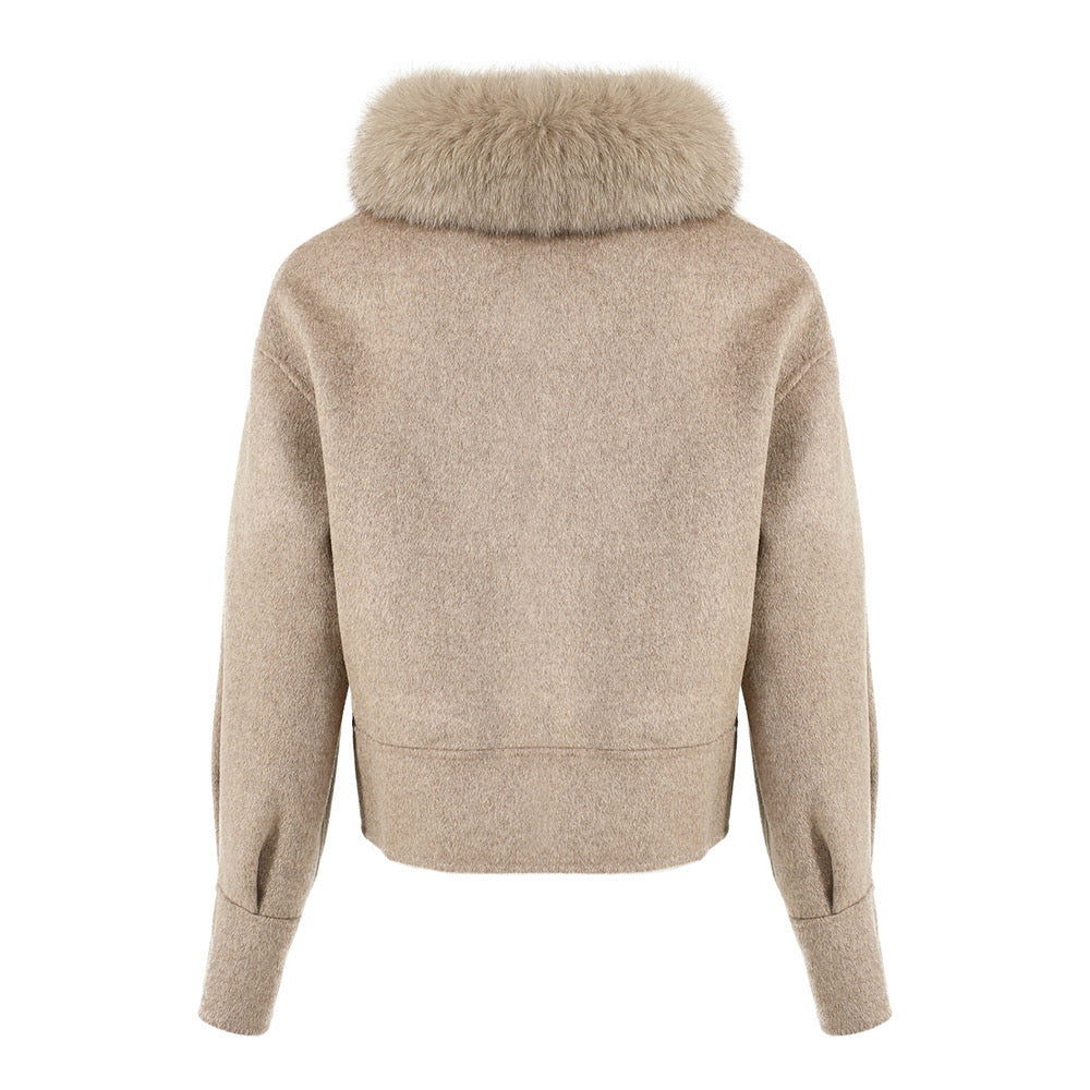 A women's taupe cashmere coat with a soft, warm texture and a plush fox fur collar. The coat features a fitted design, stylish button closures, and a flattering silhouette, perfect for a chic winter outfit.