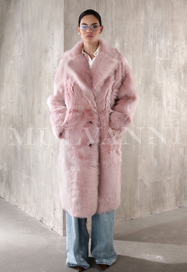 A women's pink long shearling coat with a luxurious fluffy exterior. The coat features a full-length cut, oversized lapels, and a soft lining, offering both elegance and warmth.