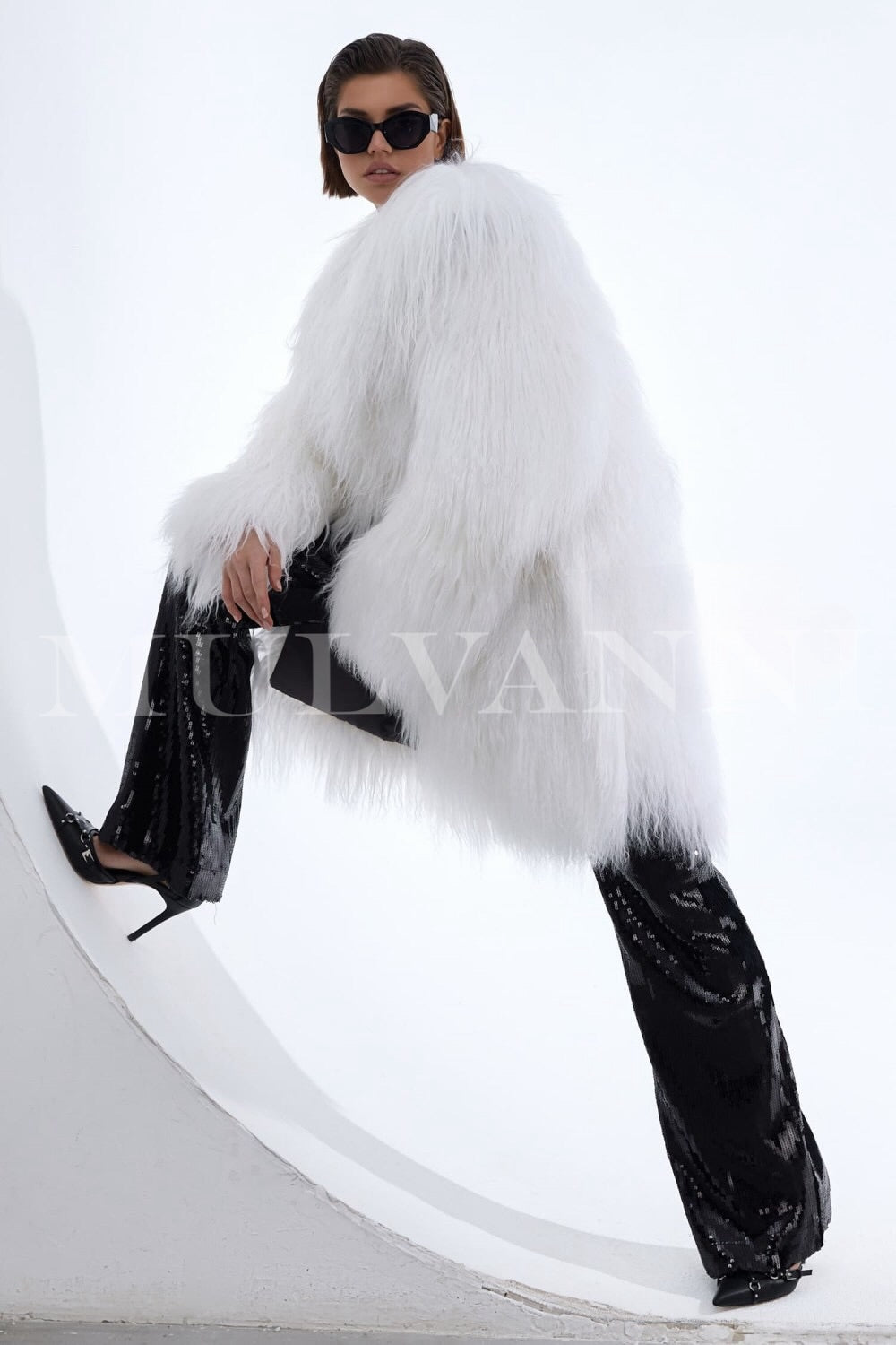 The elegant white Mongolian coat envelops the woman, highlighting her style with its fluffy, high-quality fur and sophisticated silhouette.