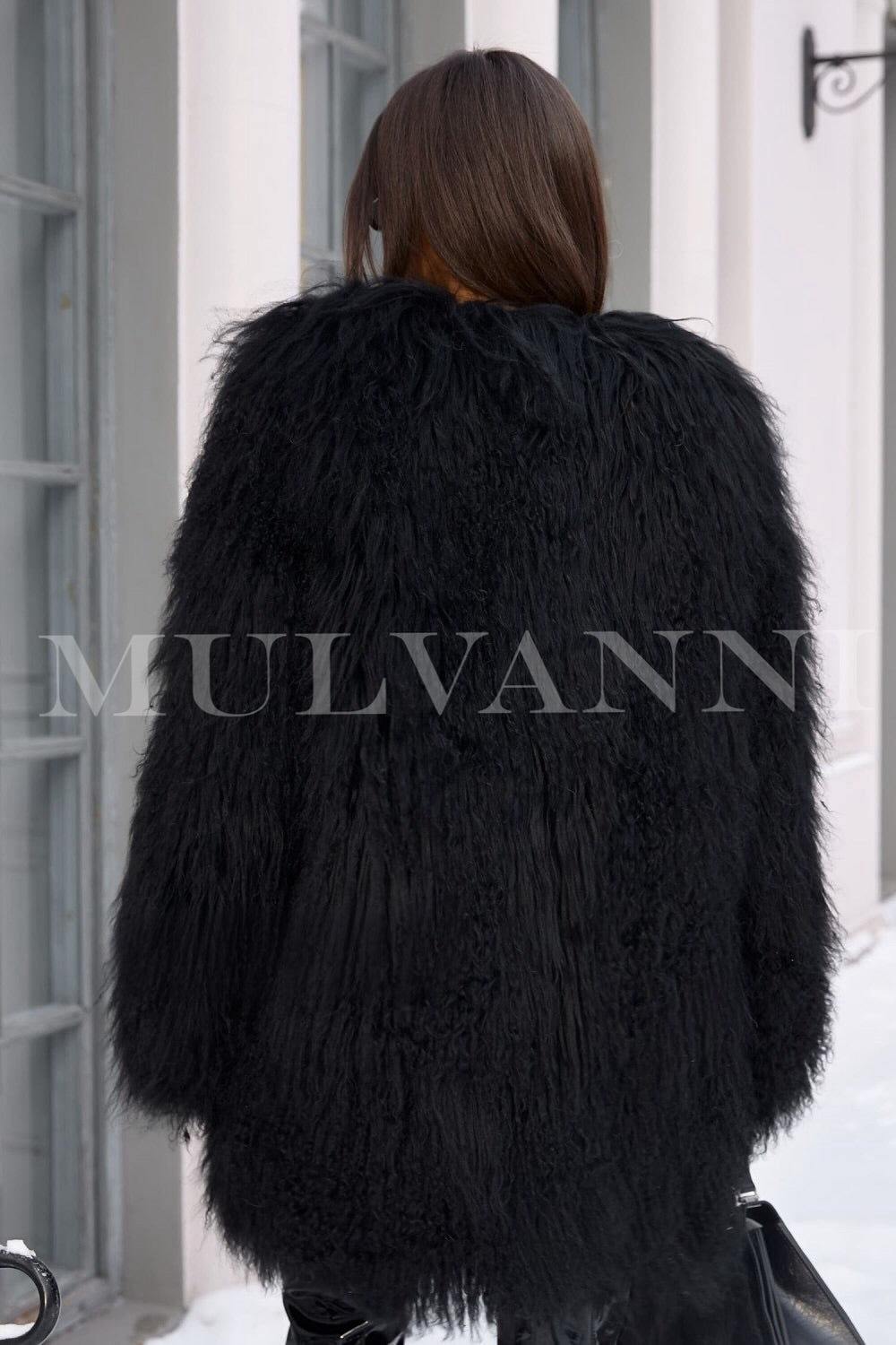 A woman wearing a chic black Mongolian fur coat, featuring a soft and luxurious feel that complements her autumn and winter outfits. The coat's stylish silhouette adds sophistication and comfort for cooler weather.