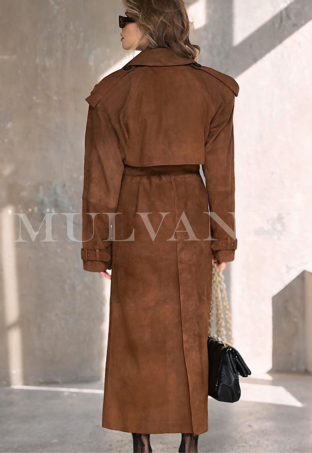 Rear view of woman wearing HATTI suede leather trench coat, showcasing stylish double-breasted design and luxurious texture in winter setting.