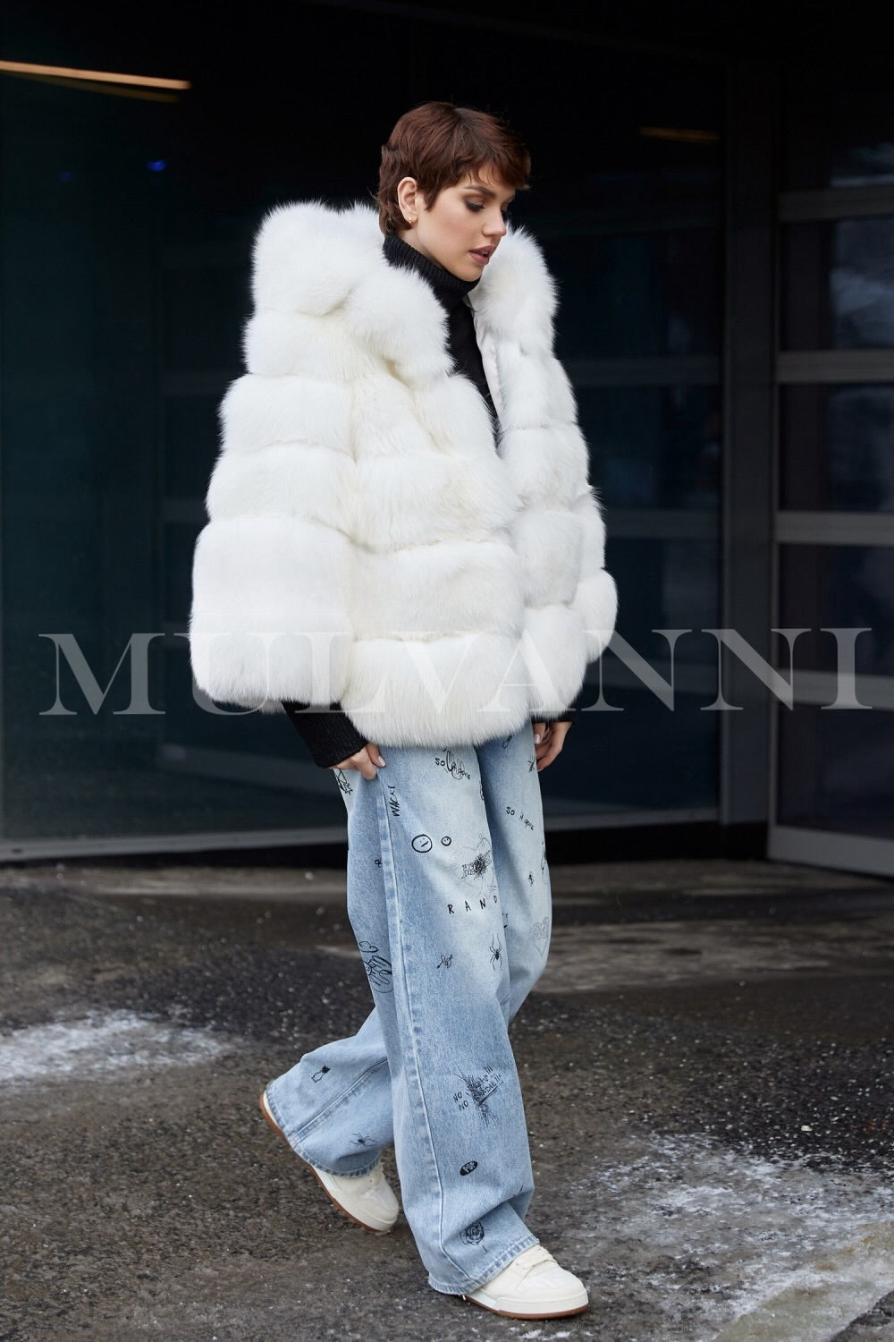 A woman in a plush white faux fur coat featuring a cozy hood, highlighting its soft and inviting fabric. The coat combines warmth and style, making it an ideal choice for chilly weather.