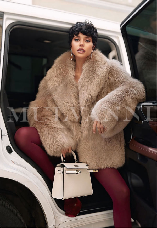 Woman wearing ROMINA luxurious faux fur coat in taupe color, stepping out of a car while holding a stylish white handbag