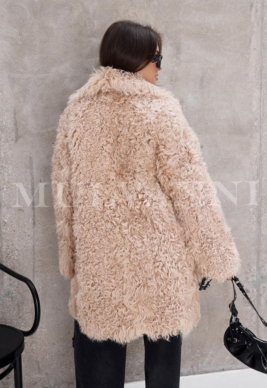 Woman wearing a premium shearling coat offering a plush, warm interior that ensures comfort during cooler months.