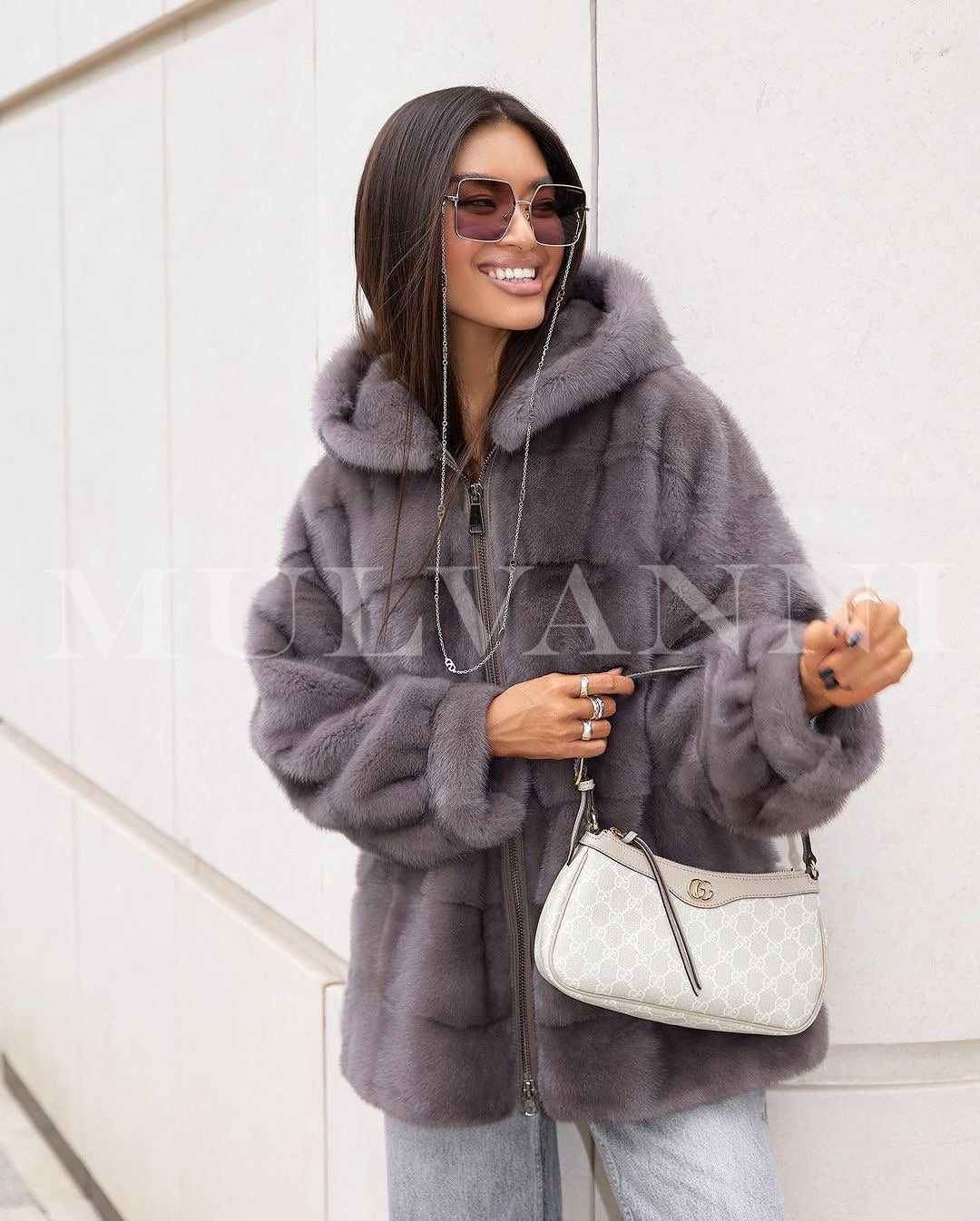 A short grey mink coat for women with a plush fur texture and an hood. The coat features a sleek, cropped design with wide lapels and a rich, glossy finish, exuding elegance and luxury.