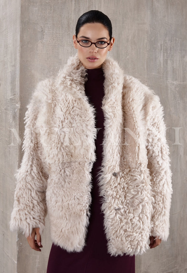 A short beige shearling coat for women, featuring a soft, fluffy lining and a cropped design. The coat has wide lapels, a relaxed fit, and button closures, offering warmth and a casual, stylish look.