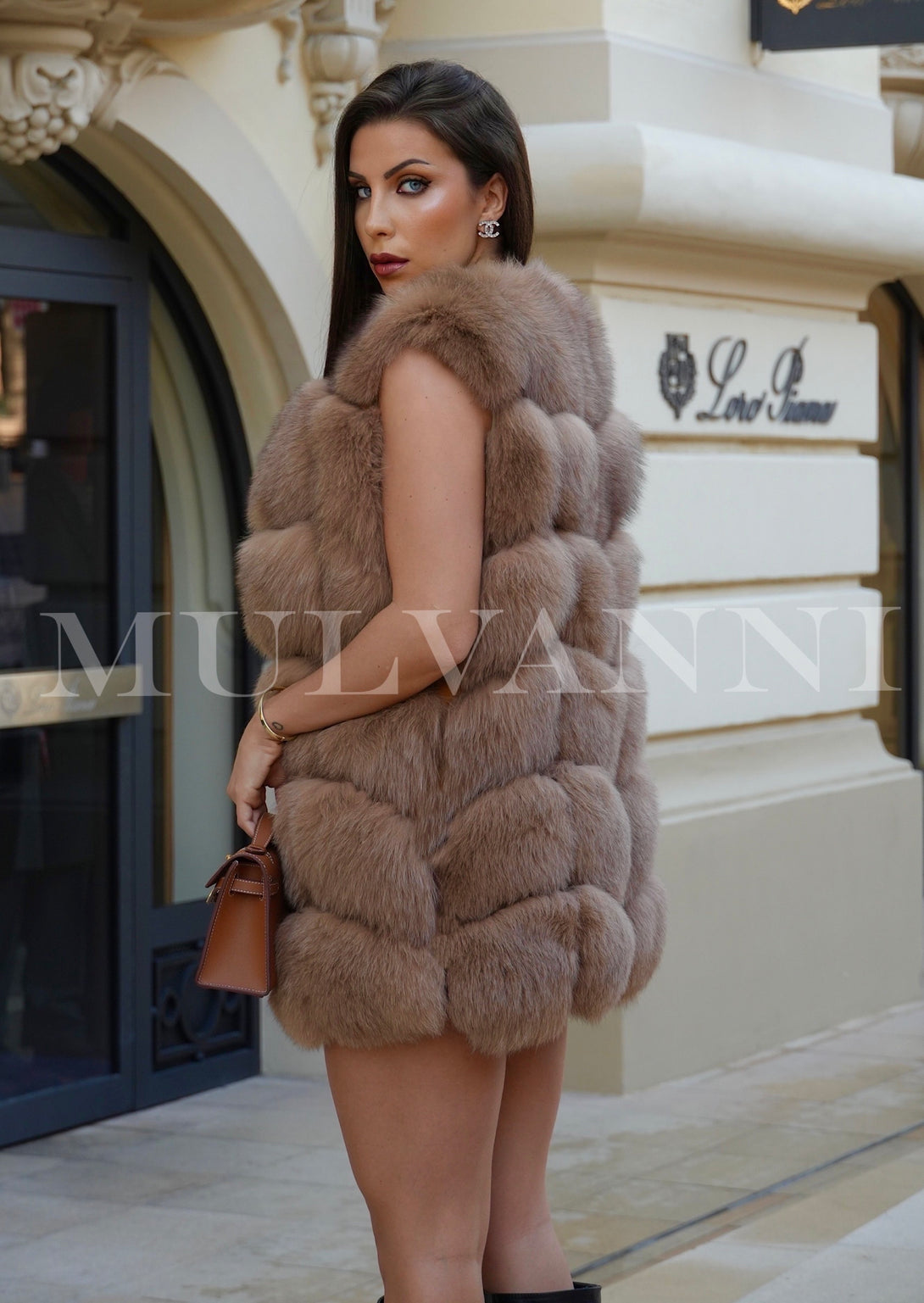 A woman dressed in a soft camel-colored fox fur vest, emphasizing its rich quality and elegance. The vest provides warmth while elevating her winter ensemble.