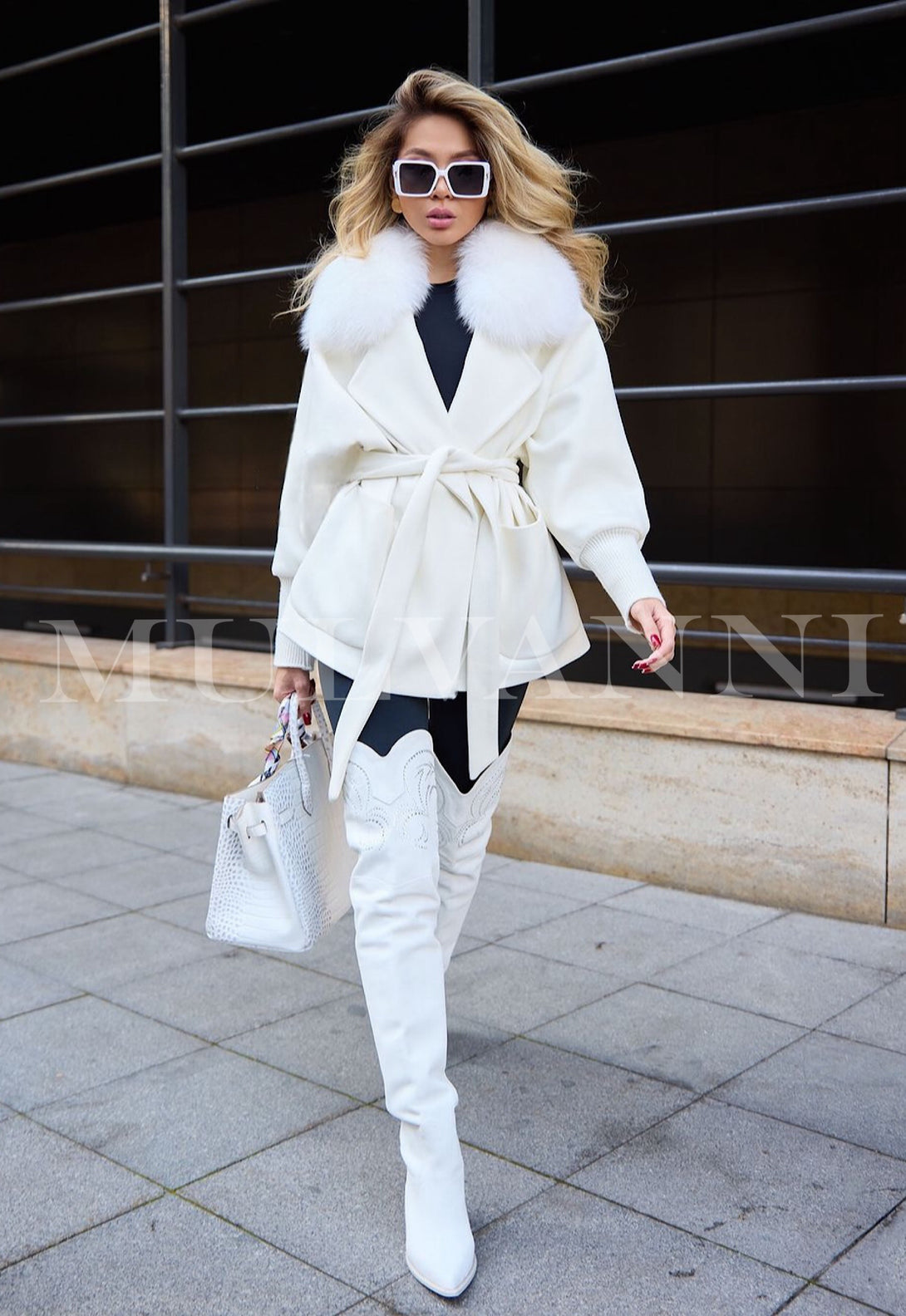 A women's loose white cashmere coat with a plush, cozy feel and beautiful fox fur collar. The coat features a relaxed silhouette, wide sleeves, and an open front, offering an elegant yet comfortable outerwear option.