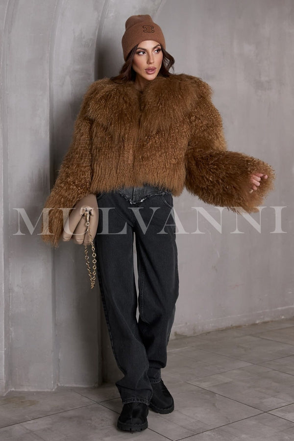 This fashionable brown short Mongolian fur coat wraps the woman in luxurious warmth, ideal for transitioning from day to evening.