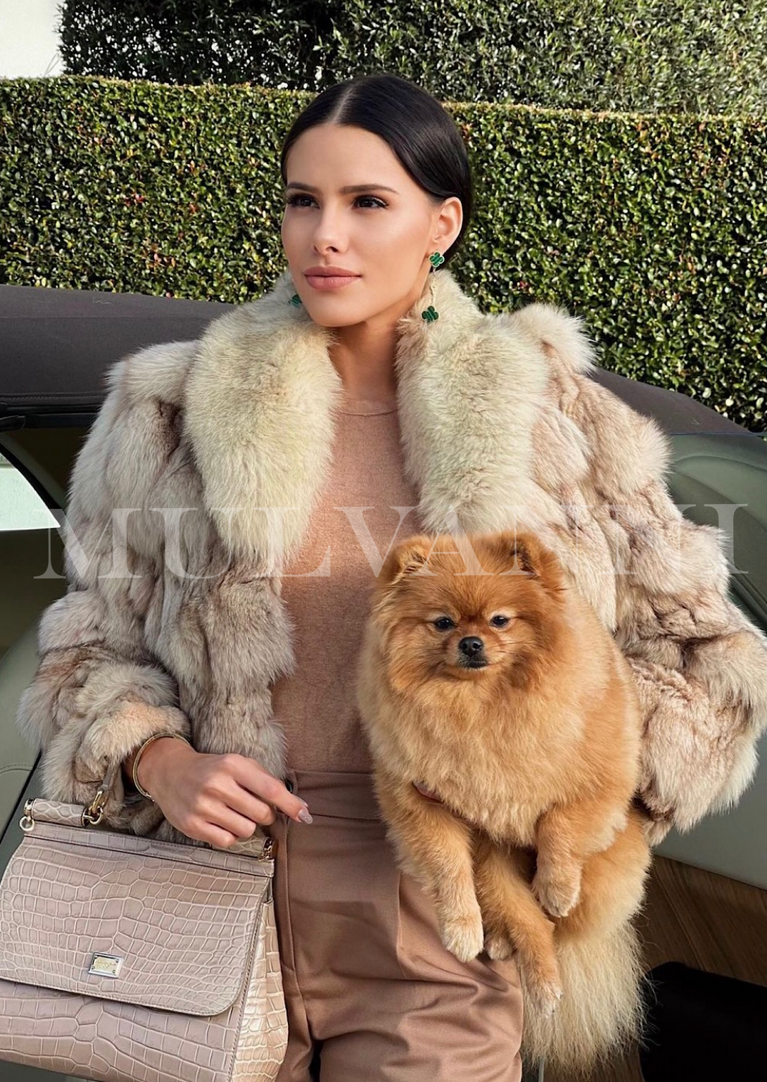 A woman dressed in a fashionable beige fox fur coat with intricate textures and a prominent collar. The luxurious coat adds warmth and elegance to her outfit.