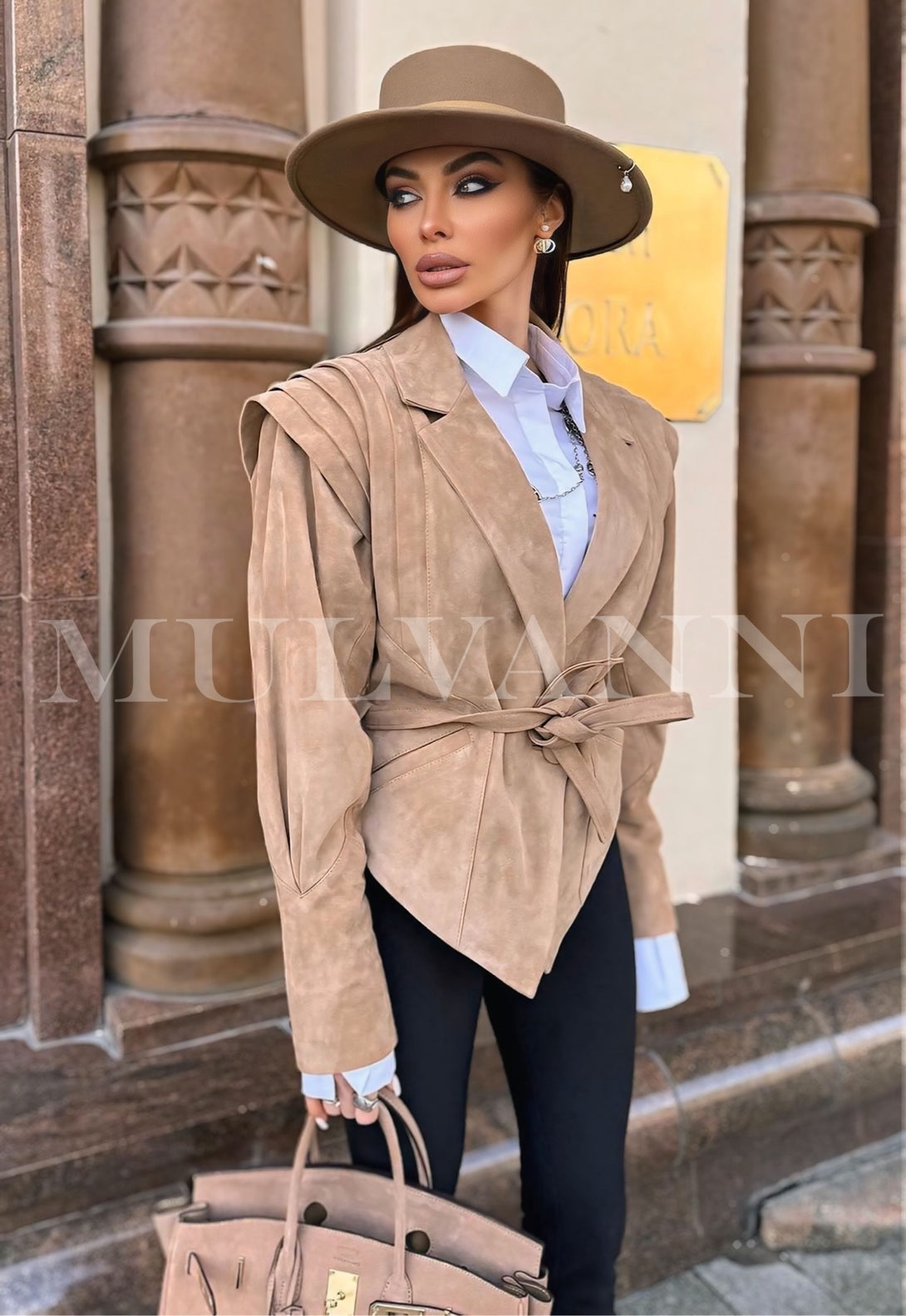 A woman wearing a beige suede jacket, modern design showcasing high quality. 