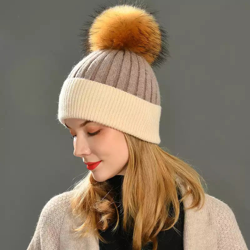 A woman wearing a fur cashmere beanie. 