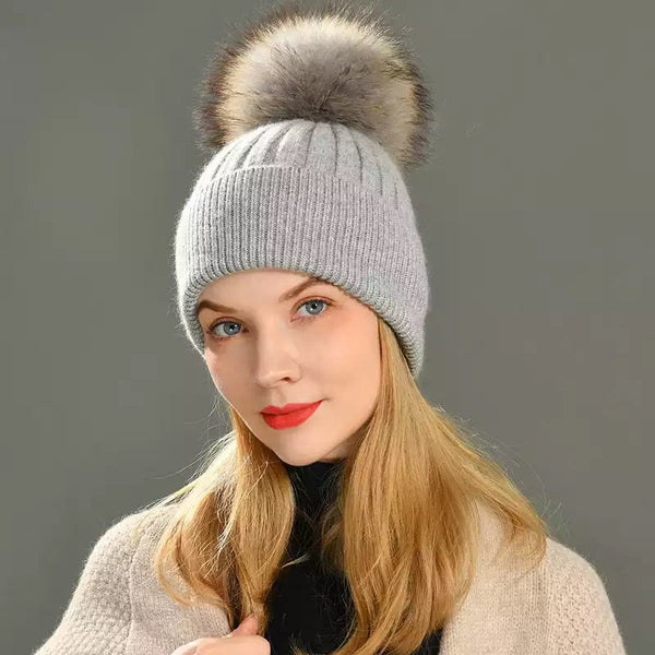 A grey pom pom hat designed by MVFURS